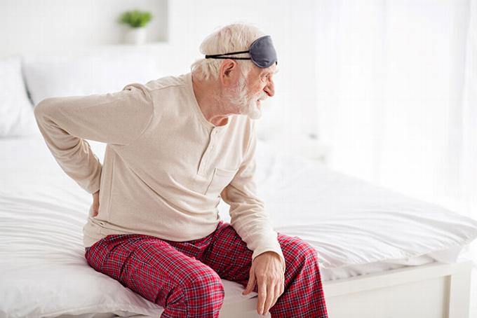 Adjustable bed for elderly shown in raised position for medical relief